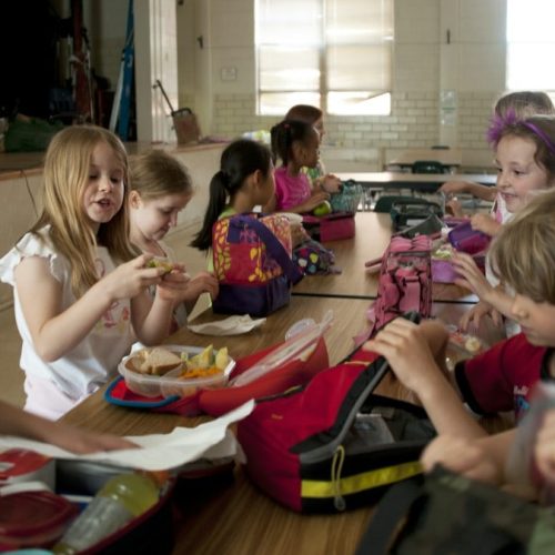 children sitting on chair eating