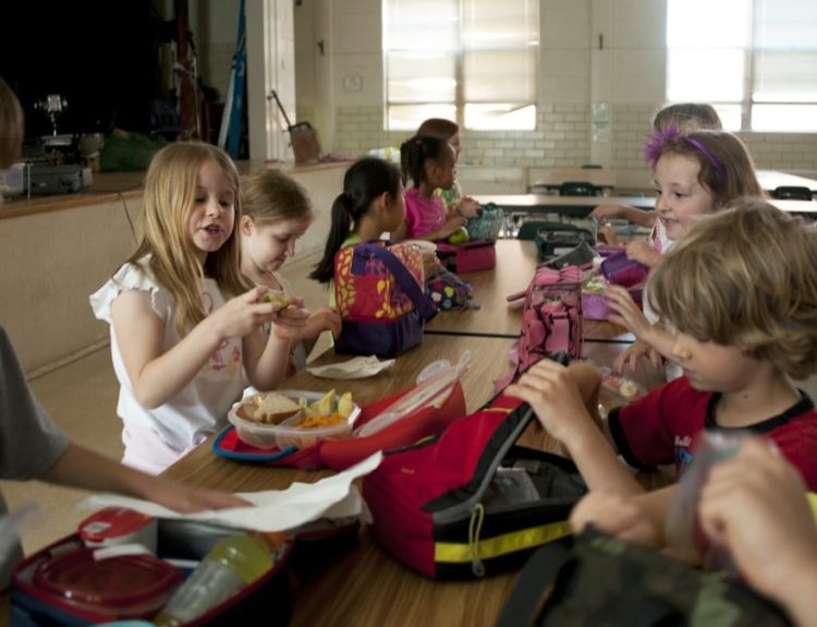 children sitting on chair eating