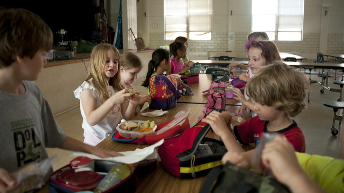 children sitting on chair eating